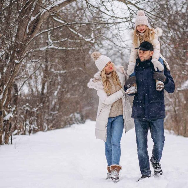 Para z dziewczynką spacerują po śniegu